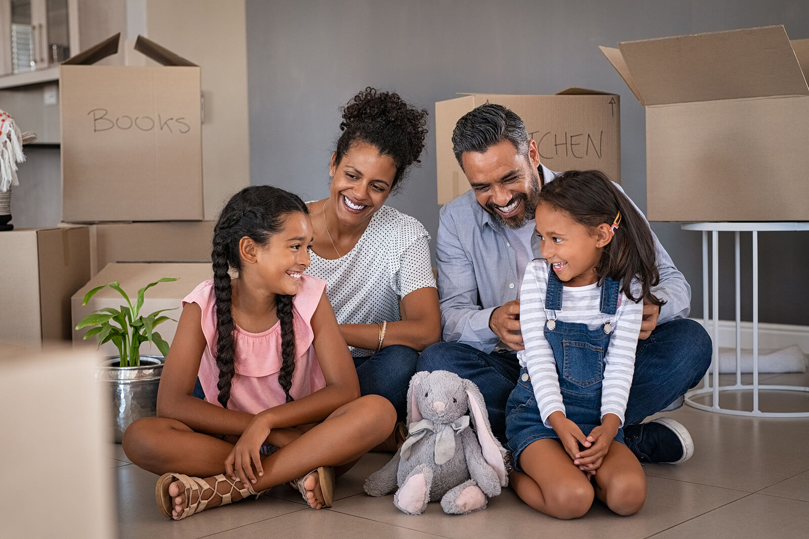 Happy family sitting on the floor of the new house they bought with a mortgage loan.