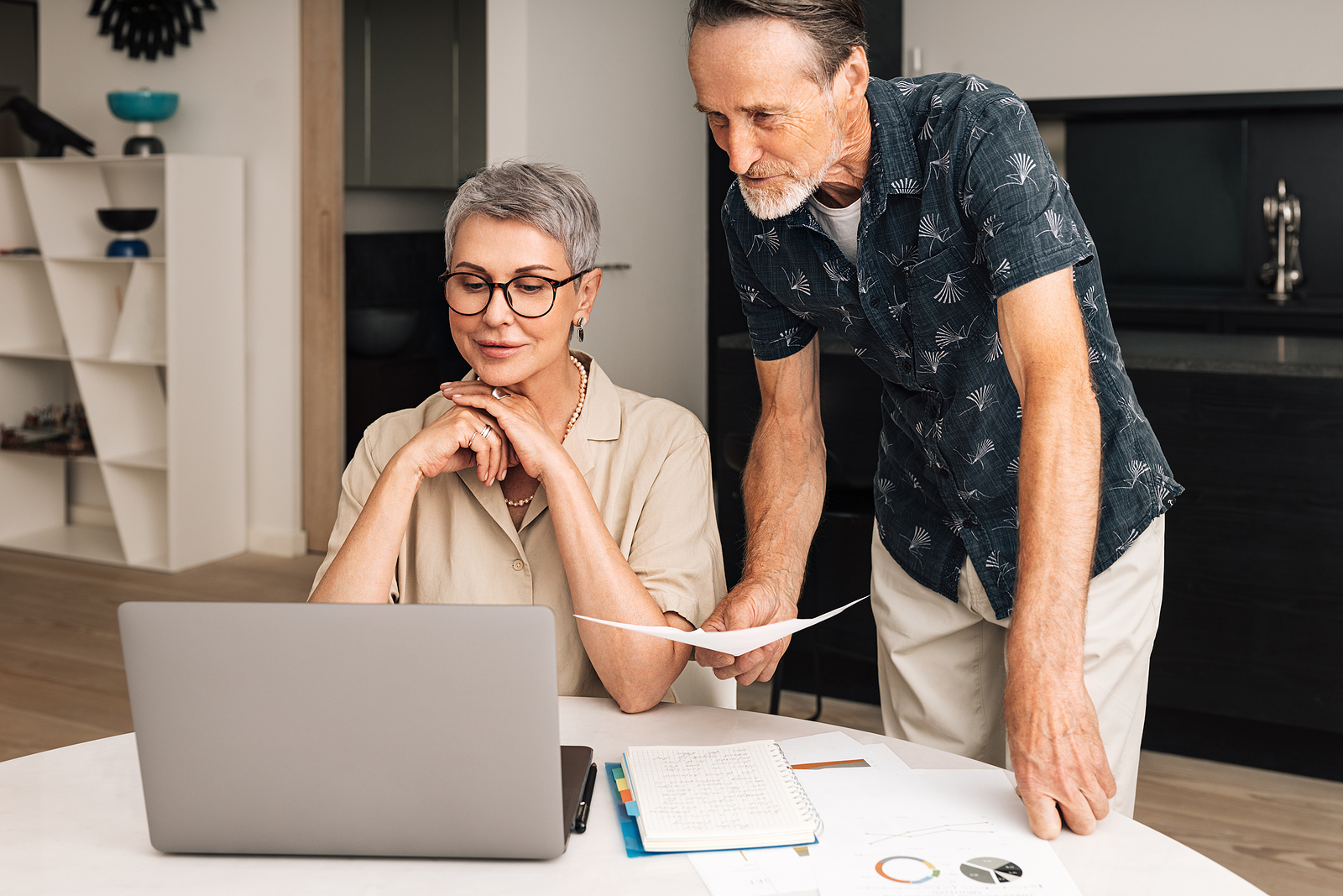 a man and woman look at their online bank and loan accounts together.