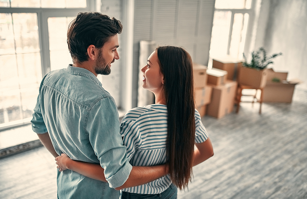 after learning the stages of buying a house, a young couple embraces as they move into their new home
