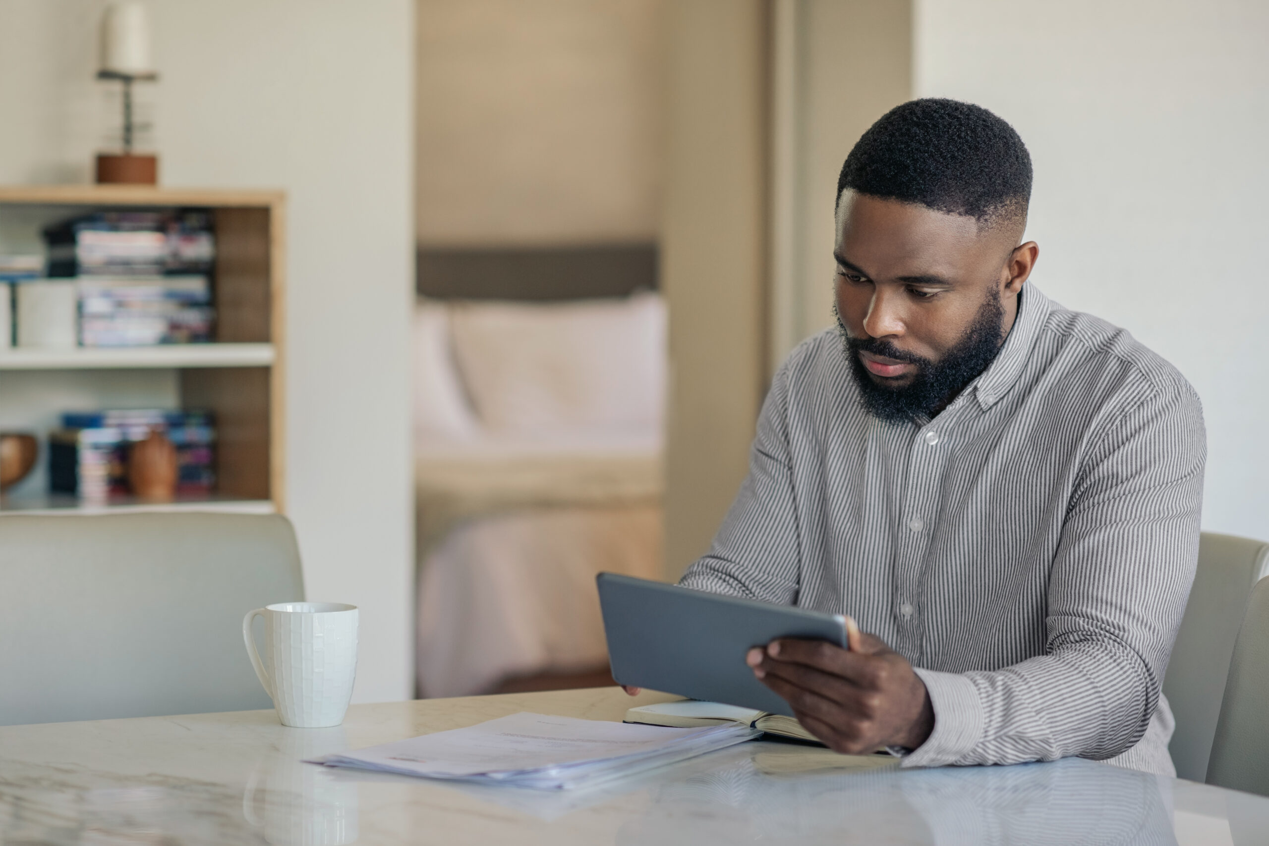 A man on a tablet researching if applying for a credit card would hurt his credit.
