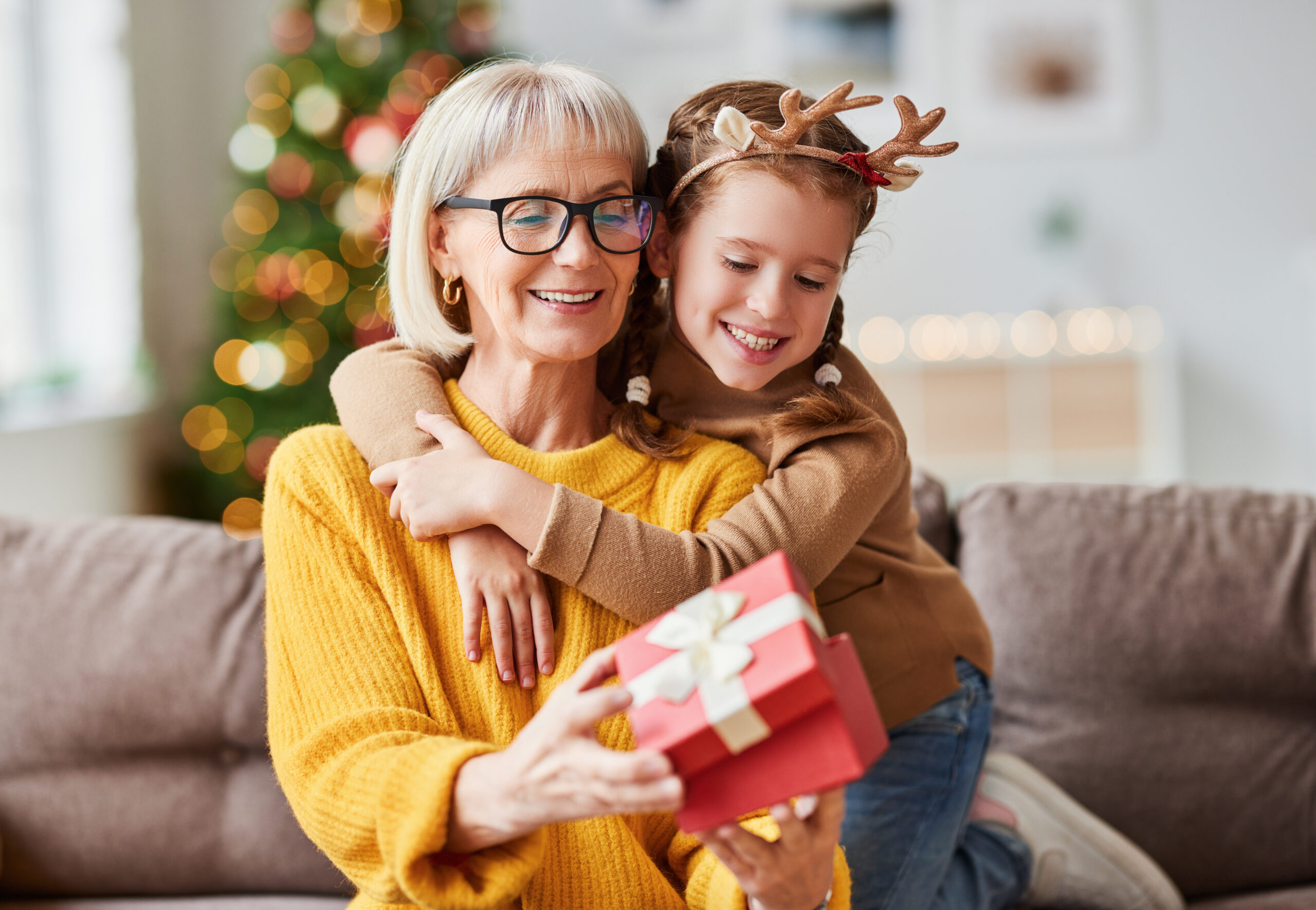 A little girl gives her grandma a present paid for with funds from a Christmas Club Savings Account.