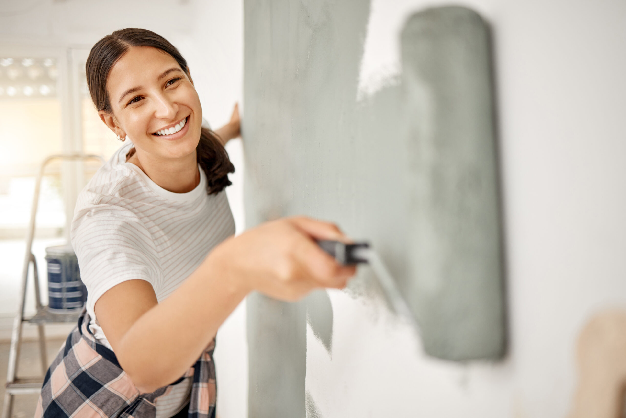 A woman paints a wall as part of a home improvement project funded by a HELOC