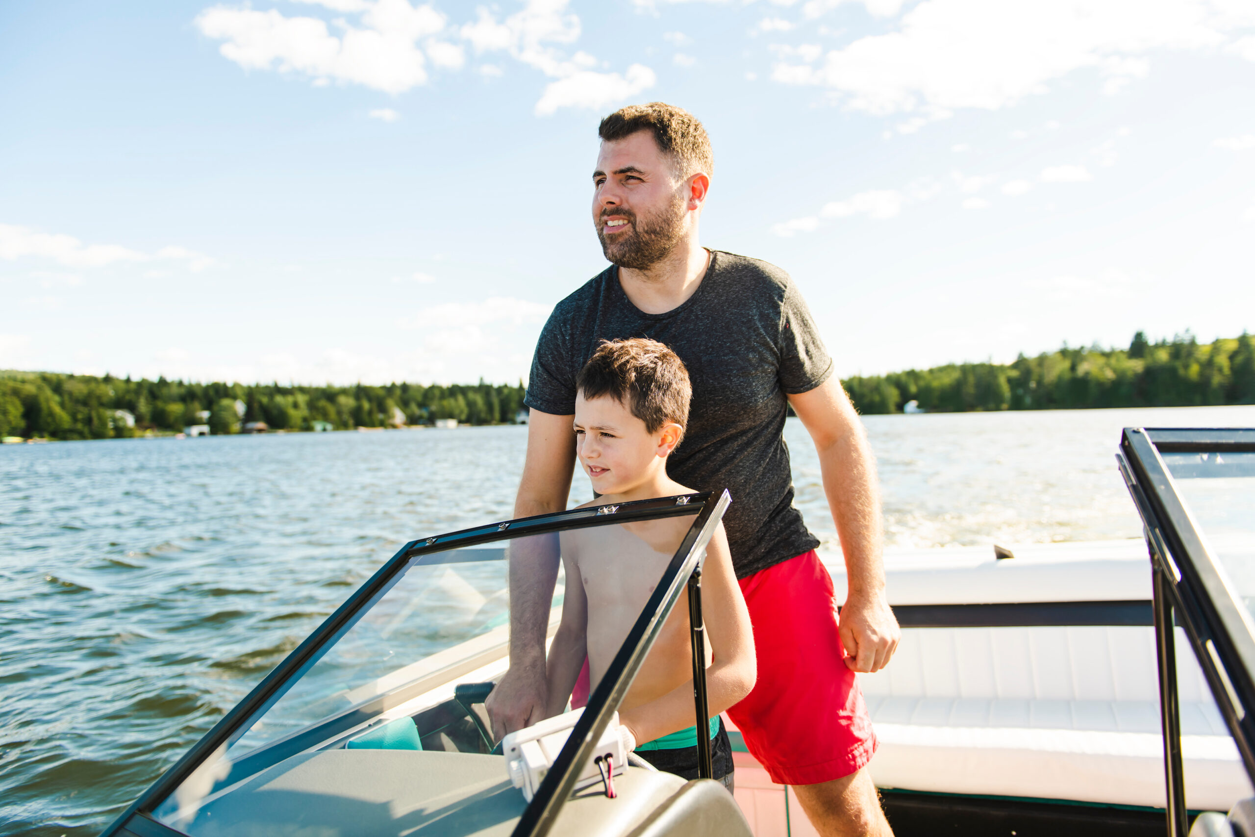 A man and his son drive a boat in a lake
